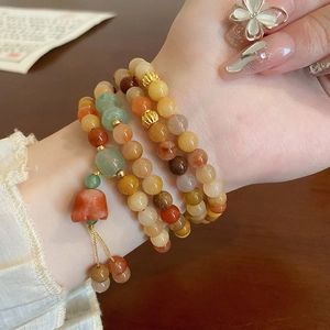 Mehrlagiges Achat-Perlenarmband mit bunten Steinen am Handgelenk einer Frau gezeigt