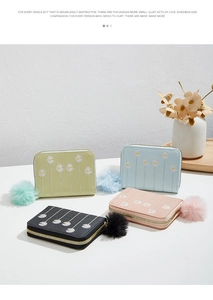 Close-up of pastel faux leather mini purses with embroidered daisies and pom-poms