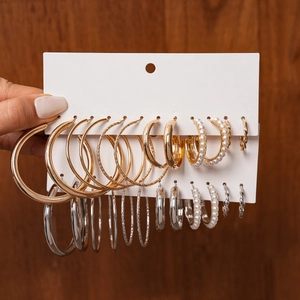 Close-up of 12-pair pearl and geometric hoop earring set in gold and silver finish