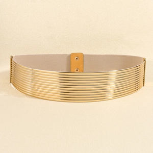 Detail van brede elastische jurkriem met goudkleurige staven en beige stretchstof