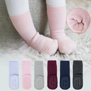 Detailed view of non-slip grips and thick terry lining on baby lace cotton socks