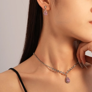 Detail view of pink teardrop zircon jewelry set with necklace and earrings on a model