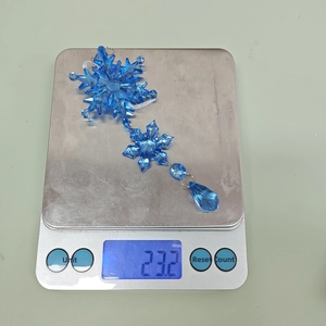 Blue acrylic snowflake and teardrop pendant ornament showing 23.2g weight on scale