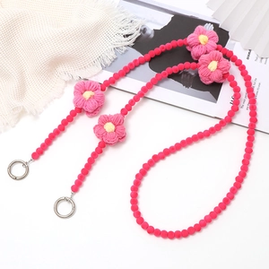 Detailed view of plush pink floral phone strap with soft beads and metal ring buckles