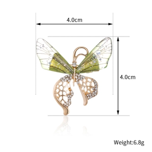 Elegante gouden vlinderbroche met groene kleurverloop vleugels en witte strassteentjes