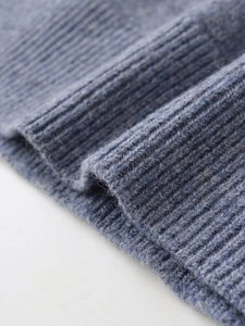 Close-up detail of blue cashmere blend knit polo showing ribbed cuffs and soft texture