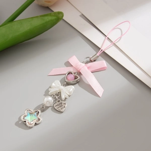 Detail of pink ribbon bow and heart pendant with Made with Love engraving on a phone strap