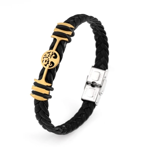 Detail of black braided leather bracelet with golden tree of life charm and silver clasp