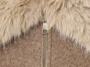 Macro detail of camel wool coat featuring faux fur collar and premium golden metal zipper