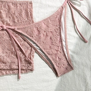 Detail shot of pink lace bikini swimwear featuring intricate floral hollow-out patterns