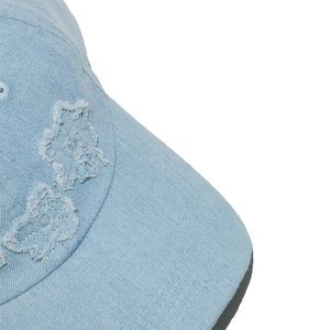 Macro shot of light blue denim baseball cap featuring distressed star-shaped fringe detail