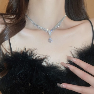 Close-up of sparkling waterdrop pendant necklace worn by a model in luxury silver finish