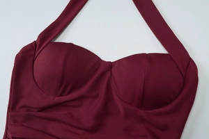 Detail of burgundy halter neckline with built-in padded cups and fine knitted texture