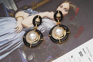Détail de boucles d'oreilles perles en émail vintage avec accents dorés et oxydes