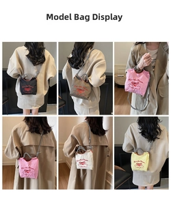 Detail of the nylon crossbody bag showing the red bow embroidery and textured fabric