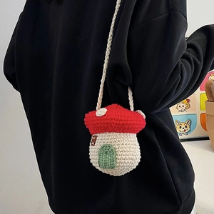 Handmade mushroom crochet crossbody bag in red and white worn by a model