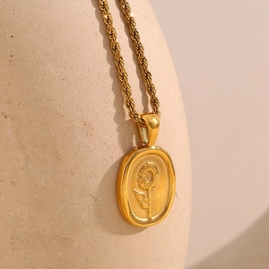 Vue détaillée d'un pendentif tournesol plaqué or 18 carats avec une chaîne torsadée sur un pot