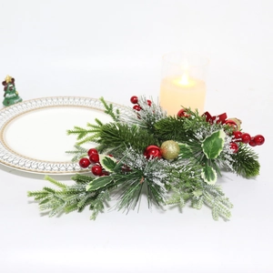 Close-up of frosted Christmas swag with red berries, pine needles and gold ornaments