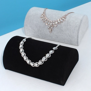 Luxury crystal necklaces displayed on black and grey velvet half-round jewelry stands