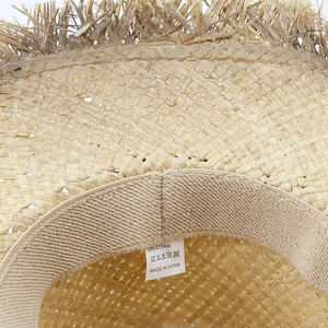 Detail of western raffia cowboy hat featuring 100% straw weave and sweatband with label