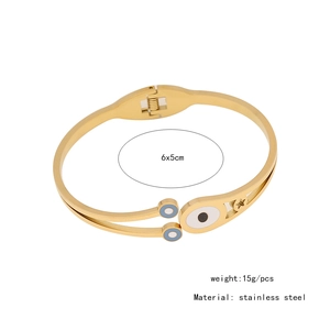 Detail of gold stainless steel bangle with evil eye enamel and star cutouts, 6x5cm size