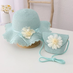 Close-up of light blue straw hat and matching floral bag with woven lace details