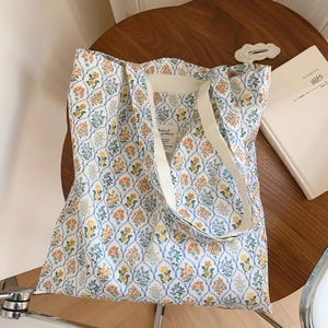 Sac fourre-tout en toile à motifs floraux orange et bleu sur table en bois