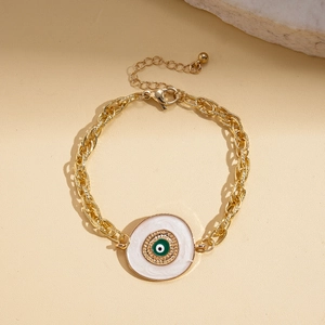 Vue détaillée d'un bracelet gourmette doré avec pendentif œil grec en émail vert