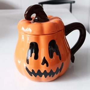 Halloween pumpkin ceramic mug with black lid and face pattern on white background