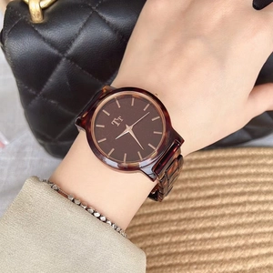 Detail shot of a women's watch with tortoiseshell texture and a minimalist brown dial