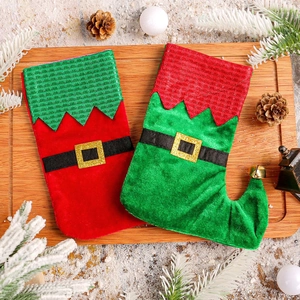 Chaussettes de Noël elf avec clochettes dorées et boucle de ceinture sur plateau festif