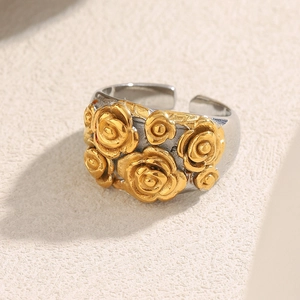 Macro view of vintage two-tone floral ring with gold rose reliefs and adjustable band