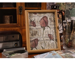 Detail of vintage wooden frame with red roses and sheet music in a retro artistic setting