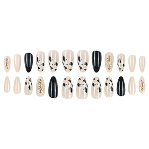 Set of almond cow print press-on nails with 3D gold accents and black matte finish