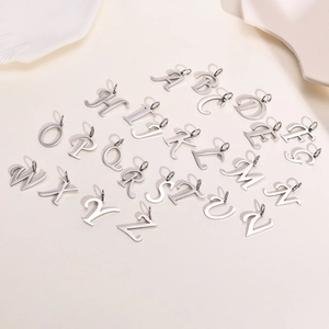 Macro view of polished silver titanium steel 26 English letter pendants for DIY jewelry making