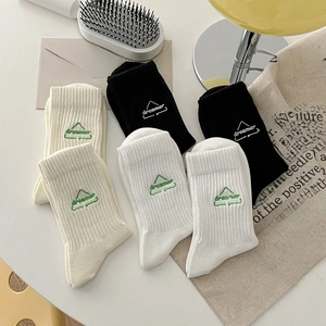 Three pairs of cotton crew socks in black, white, and beige with dreamer embroidery
