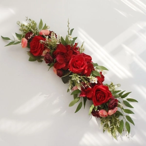 Detailed view of red silk roses and green eucalyptus leaves for wedding table decor