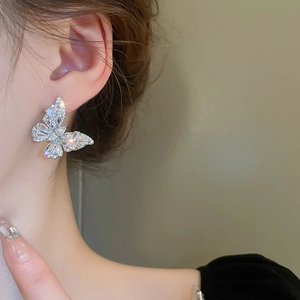 Detailed close-up of a silver butterfly stud earring with sparkling cubic zirconia inlay