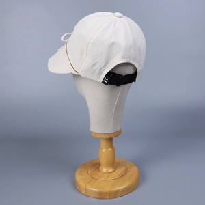 Adjustable black strap with kt buckle on cream nylon baseball cap back view