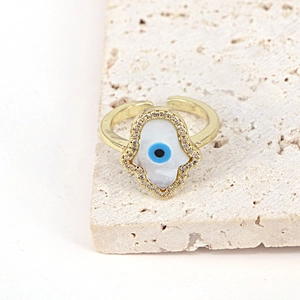 Detailed macro of golden Hamsa Hand ring with evil eye mother of pearl inlay