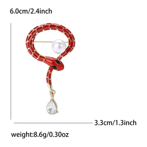 Exquisite snake brooch with red enamel, gold texture, and teardrop crystal charm