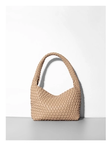 Dettaglio della trama in pelle intrecciata a mano color albicocca della borsa a tracolla