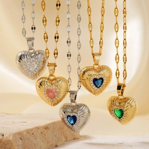 Macro view of heart-shaped zircon pendants with colorful gems on textured stone