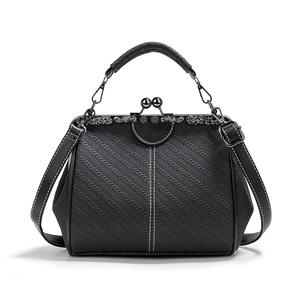 Close-up of a vintage black woven PU leather doctor bag with a floral engraved metal clasp