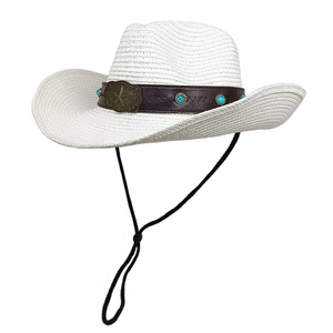 Détail d'un chapeau de cow-boy en paille blanche avec ruban en cuir et clous turquoise