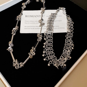 Detailed view of silver beaded fringe necklace and woven choker in a jewelry box