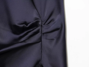 Vue détaillée du tissu satiné bleu marine avec texture plissée élégante et drapé