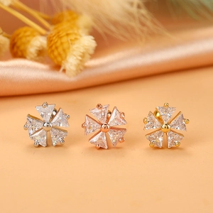 Detailed view of three flower stud earrings with marquise cubic zirconia in gold and silver