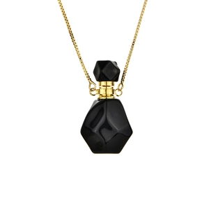 Gold chain necklace featuring a geometric black stone perfume bottle pendant charm