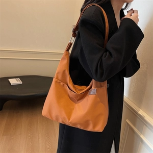 Classic large capacity orange-brown canvas tote bag for women shown in a modern home setting